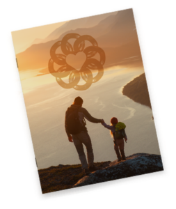 Landscape image of a body of water in between hillsides. An adult and child are standing on a rock holding hands