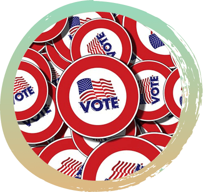 A pile of round stickers with an inner red circle around the edge and an American flag in the center with the word "Vote" below the flag.