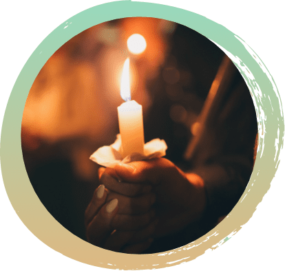 A single white candle being held with two hands